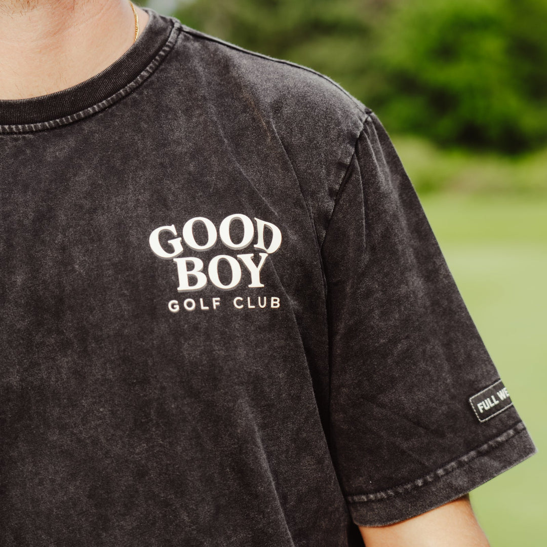 A close-up of a person wearing a dark washed black t-shirt with &